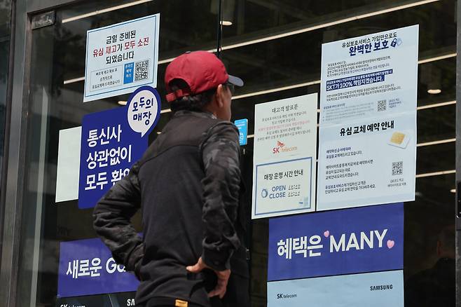 SK텔레콤이 가입자 유심(USIM) 정보 유출 사태로 오는 5일부터 신규 가입자 모집을 중단한다고 밝힌 2일 서울 시내의 한 SK텔레콤 대리점 앞에서 한 소비자가 유심 재고 소진 및 유심보호서비스 관련 안내문을 살펴보고 있다./연합뉴스