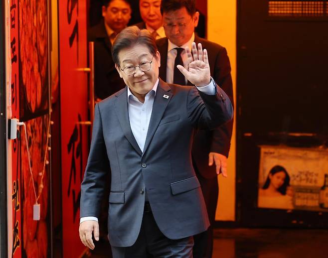 이재명 더불어민주당 대통령 후보가 1일 서울 종로구의 한 포차 식당에서 ‘당신의 하루를 만드는, 보이지 않는 영웅들’이란 주제로 열린 배달 라이더, 택배 기사 등 비(非)전형 노동자들과 간담회를 마친 뒤 나서며 손인사를 하고 있다. (공동취재) 2025.5.1/뉴스1