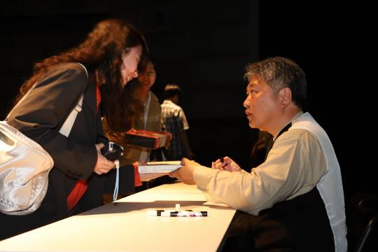 지난달 30일 서울 광화문에 위치한 예술 전용 영화관 씨네큐브에서 진행된 마스터클래스에서 고레에다 히로카즈 감독이 관객들에게 자필 사인을 전달하고 있다. 태광그룹 제공.