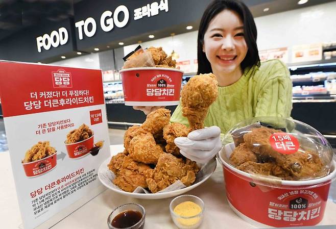 2일 서울 등촌동 '홈플러스 메가 푸드 마켓' 강서점에서 모델이 신메뉴 '당당 더큰후라이드치킨(9990원)'을 선보이고 있다. 홈플러스 제공