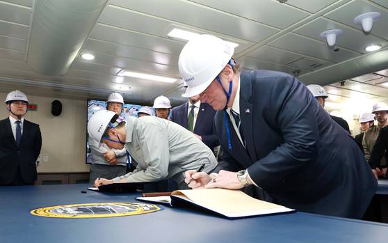 존 펠란 미 해군성 장관과 정기선 HD현대 수석부회장이 HD현대중공업이 건조한 이지스 구축함 정조대왕함에 올라 방명록에 서명하는 모습. 사진 HD현대중공업