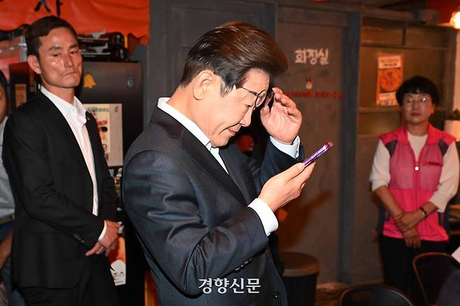 이재명 더불어민주당 대선 후보가 지난 1일 서울 종로구의 한 음식점에서 열린 비전형 노동자 간담회 종료 후 당 관계자에게 전달받은 휴대전화를 확인하고 있다. 조태형 기자