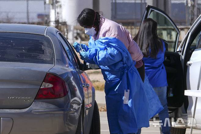 [세미놀=AP/뉴시스] 지난 2월 21일 미국 텍사스주 세미놀의 이동식 검사장에서 보건소 직원이 차량 탑승자를 대상으로 홍역 검사를 실시하는 모습. (사진은 기사 내용과 관련이 없습니다.) 2025.02.27.