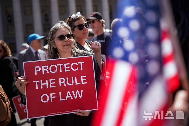 [워싱턴=AP/뉴시스]국제 노동절인 1일(현지 시간) 미국 전역에서는 도널드 트럼프 행정부에 반대하는 집회가 동시다발적으로 벌어진 가운데, 미국 뉴욕에서 열린 집회에 한 참가자가 '법치를 보호하라'는 팻말을 들고 있다. 2025.05.02.