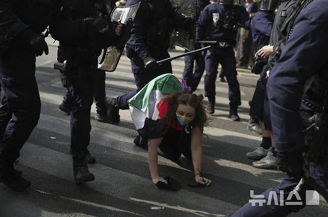 [파리=AP/뉴시스] 1일(현지 시간) 프랑스 파리에서 열린 노동절 시위 중 한 시위 참가자가 경찰의 저지에 넘어지고 있다. 2025.05.02.