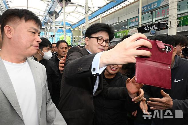 [창원=뉴시스] 차용현 기자 = 2일 오전 경남 창원시 마산어시장을 방문한 한동훈 제21대 대통령 선거 국민의힘 경선 후보가 시민과 기념촬영을 하고 있다. 2025.05.02.con@newsis.com
