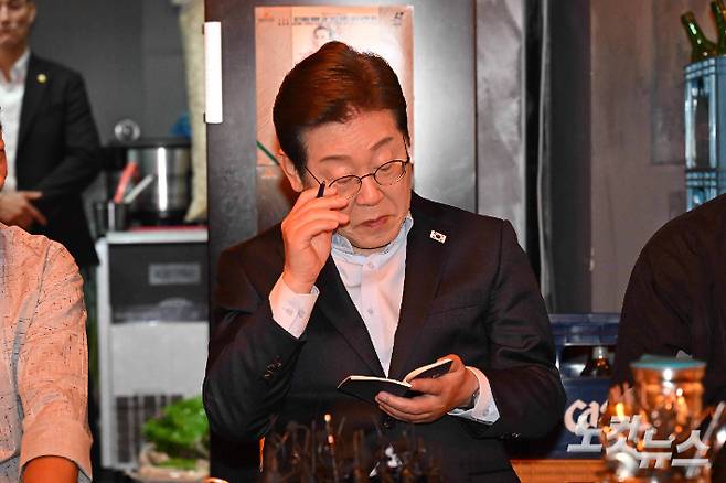 이재명 더불어민주당 대선 후보가 1일 서울 종로구의 한 음식점에서 열린 비전형 노동자 간담회에 참석해 수첩을 살펴보고 있다. 황진환 기자