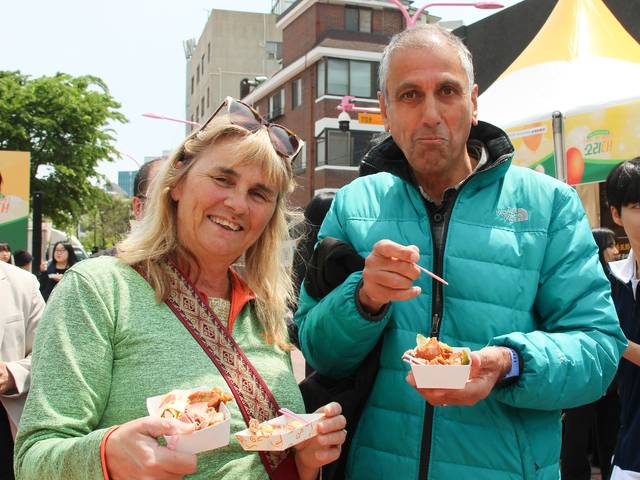 2일 서울 마포구 홍대레드로드 R1 광장에서 외국인 관광객들이 국산 오리고기 요리를 맛보고 있다.