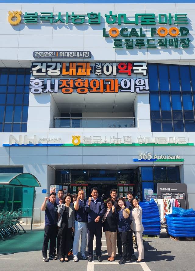 경북 경주 불국사농협 성장을 주도하고 있는 하나로마트 앞에서 김영도 조합장(사진 앞줄 가운데)과 직원들이 활짝 웃어보이고 있다.