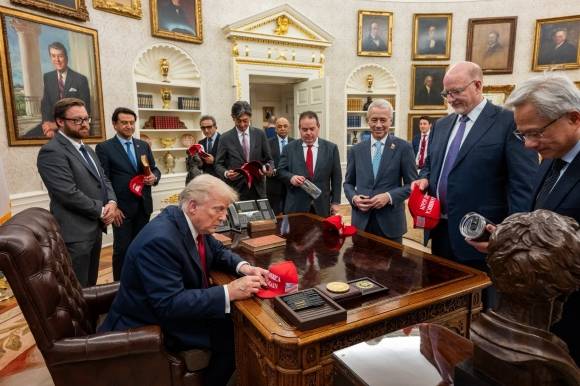 트럼프, 글로벌 CEO들에게 ‘MAGA 모자’ 나눔 - 도널드 트럼프 미국 대통령이 30일(현지시간) 백악관 집무실 의자에 앉아 ‘마가’(MAGA·미국을 다시 위대하게) 모자에 친필 사인을 한 뒤 글로벌 기업 최고경영자(CEO)들에게 나눠 주고 있다. 트럼프 대통령은 이날 초대한 20여명의 CEO 중 21억 달러 규모 대미 투자를 결정한 현대차의 호세 무뇨스 사장을 가장 먼저 거명하며 “고맙다”고 치켜세웠다. 댄 스커비노 백악관 부비서실장 X 캡처