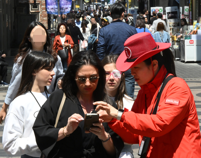 29일 서울 중구 명동거리를 찾은 한 외국인 관광객이 안내원으로부터 도움을 받고 있다. 오승현 기자