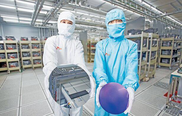 경북 구미에 있는 SK실트론 생산 시설에서 연구원들이 반도체용 핵심 소재인 웨이퍼를 들어 보이고 있다. 사진제공=SK실트론