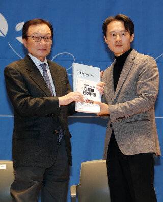 2021년 11월 19일 서울 여의도 국회 의원회관 대회의실에서 열린 더불어민주당 인재 영입 10호 환영 행사에서 이해찬 대표(왼쪽)가 이탄희 전 판사에게 당헌 당규 책자를 선물하고 있다. 동아DB