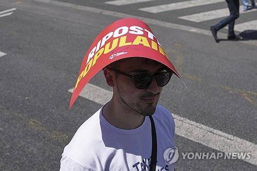 파리 도심 노동절 시위에 참가한 시민이 손팻말로 더위를 피하고 있다.  [AP 연합뉴스 자료사진. 재판매 및 DB 금지]