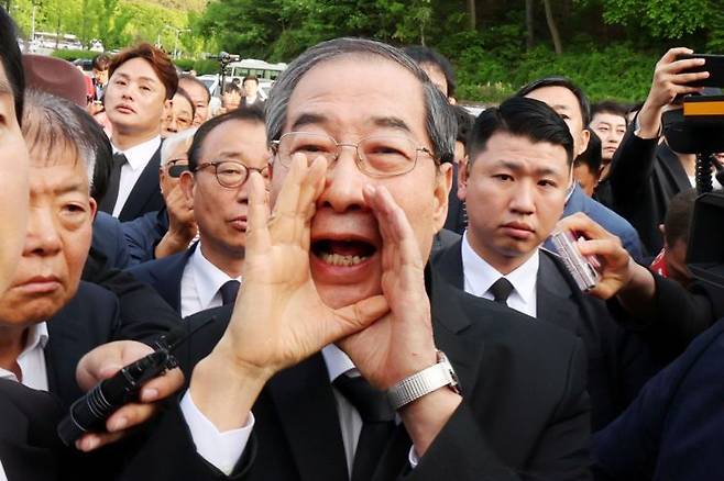 지난 2일 오후 광주 북구 국립 5·18 민주묘지를 찾은 한덕수 전 총리가 광주비상행동 등 시민·사회단체 관계자들의 반발에 가로 막히자 "저도 호남 사람"이라며 참배를 호소하고 있다. 연합뉴스