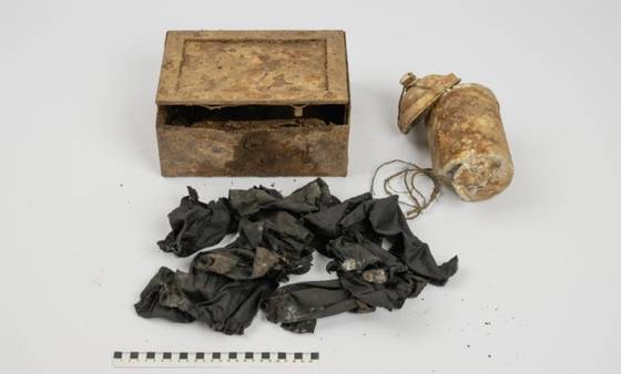 등산객에 의해 발견된 철제상자와 알루미늄 캔. 금화를 쌓고 있던 검정색 천. 사진 체코 동보헤미아 박물관