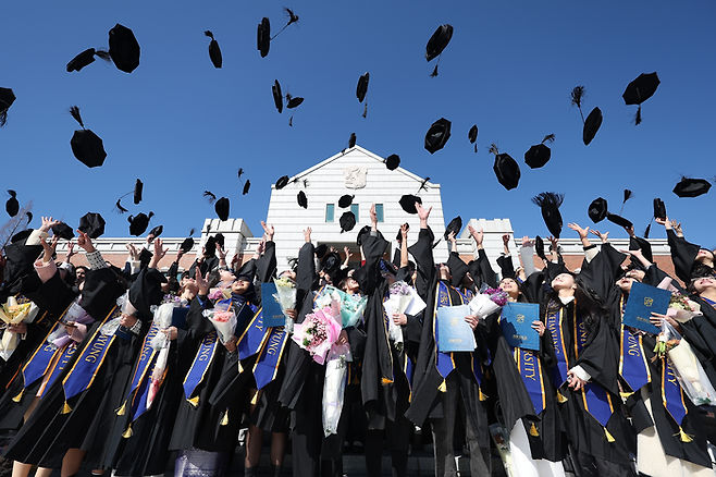 지난 2월 대구 달서구 계명대학교 성서캠퍼스에서 열린 2024학년도 전기 학위수여식에서 졸업식을 마친 외국인 유학생들이 학사모를 던지며 기념 촬영을 하고 있다. 던질 땐 좋지만 학사모 모서리에 찍히면 가마 하나 더 생기는 건 일도 아니다. [연합뉴스]