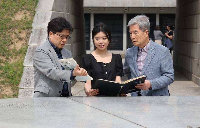 지난달 27일 서울 중구 남산골한옥마을 ‘서울 정도 600주년 기념 타임캡슐’ 광장에서 조영헌 고려대 교수와 딸 조수하 씨, 부친 조의현 씨(왼쪽부터)가 가족신문을 보며 일화를 이야기하고 있다. 이들 가족의 일상을 담은 ‘비둘기집’은 역사적 가치를 인정받아 이 타임캡슐에 실렸다. 한주형 기자