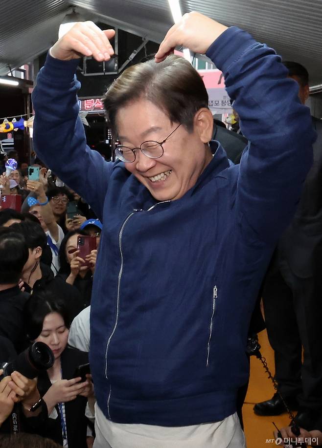 [고성=뉴시스] 조성우 기자 = 민심을 청취하는 '경청 투어'에 나선 이재명 더불어민주당 대선후보가 2일 오후 강원도 고성군 거진전통시장에서 상인들과 주민들에게 하트를 만들어 보이고 있다. 2025.05.02. xconfind@newsis.com /사진=조성우