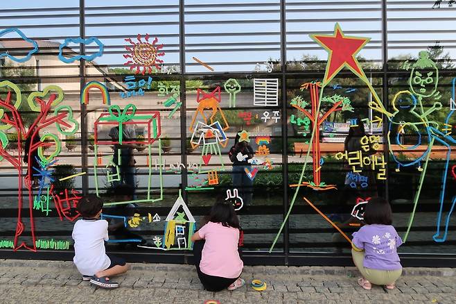 백남준아트센터 외벽을 마스킹 테이프로 꾸미는 어린이들 모습. [경기문화재단]