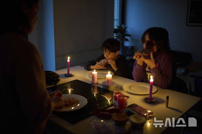 [바르셀로나=AP/뉴시스] 28일(현지 시간) 스페인에서 대규모 정전 사태가 발생하자 바르셀로나의 한 가정집에서 가족이 촛불을 켜놓고 식사하고 있다. 이날 스페인과 포르투갈 전역에서 발생한 대규모 정전으로 기차, 지하철, 항공기 등 주요 교통수단이 마비되며 피해가 이어졌다. 2025.04.29.