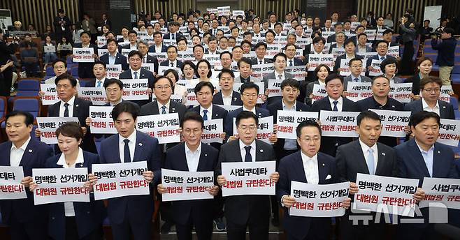 [서울=뉴시스] 조성봉 기자 = 박찬대 더불어민주당 대표 직무대행 겸 원내대표와 의원들이 1일 오후 서울 여의도 국회에서 열린 긴급 의원총회에서 손피켓을 들고 구호를 외치고 있다. 2025.05.01. suncho21@newsis.com