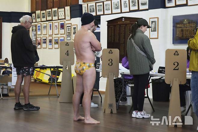 [시드니=AP/뉴시스] 3일(현지 시간) 호주 시드니의 본다이 비치에 마련된 한 투표소에서 수영복 차림의 남성이 줄을 서서 투표를 기다리고 있다. 2025.05.03.