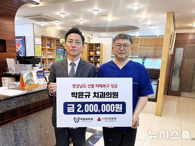 [창원=뉴시스]지난 2일 경남 창원특례시 마산합포구 소재 박윤규치과의원에서 박윤규 원장(오른쪽)이 경남사회복지공동모금회 박은덕 사무처장에게 산불 성금 200만 원 기탁증서를 전달하고 있다.(사진=경남공동모금회 제공) 2025.05.03. photo@newsis.com