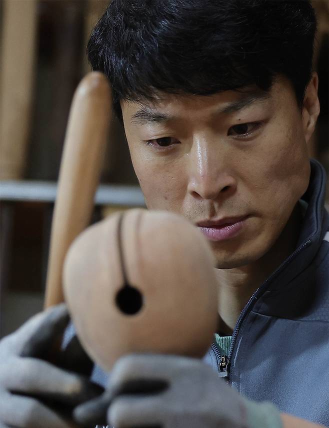 ⑦ 건조와 사포작업을 마친 목탁의 최종 소리 평가를 하고 있다.