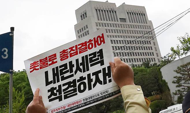 3일 오후 서울 서초구 대법원 앞에서 열린 촛불행동 주최 제138차 촛불대행진에서 참가자들이 대법원 청사 건물을 향해 '내란세력 척결하자'고 적힌 피켓을 들고 있다. 뉴스1