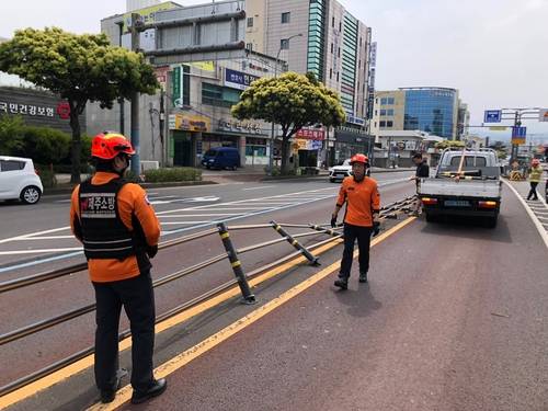 3일 제주에 불어닥친 초속 25.9m의 태풍급 강풍으로 도로 위 중앙분리대가 쓰러져 있다. 소방당국이 현장 복구 작업을 진행 중이다. 연합뉴스연합뉴스