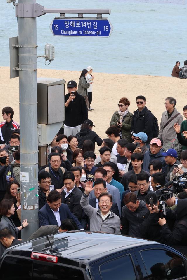 이재명 더불어민주당 대선 후보가 '골목골목 경청투어' 사흘째인 3일 강원도 동해안 지역의 민심을 공략하기 위해 강릉 안목해변 커피거리를 찾아 도민과 관광객들을 향해 인사하고 있다. 연합뉴스