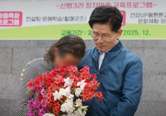 김문수 국민의힘 대선 후보가 4일 한센인 마을인 경기도 포천시 장자마을을 방문해 간담회에서 편지를 읽은 주민이 전달한 꽃다발을 받은 뒤 주민을 위로하고 있다. [연합뉴스]