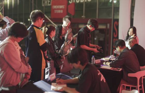 지난해 10월 열린 '부산글로벌웹툰페스터벌'에서 웹툰 팬들이 작가들에게 사인을 받고 있다. 사진 부산글로벌웹툰센터