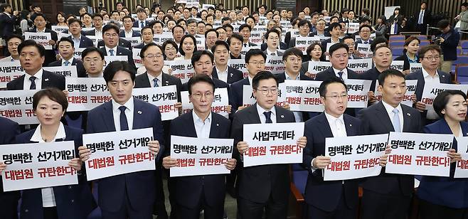 박찬대 더불어민주당 당대표 직무대행 겸 원내대표(앞줄 가운데)와 의원들이 1일 국회에서 열린 긴급의총에서 구호를 외치고 있다. 임현동 기자