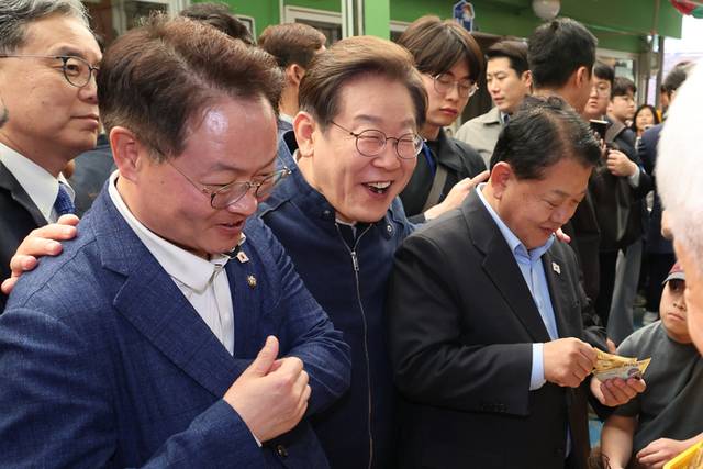 ▲ 더불어민주당 이재명 대선 후보가 ‘골목골목 경청투어’ 접경지역 방문 이틀째인 2일 강원도 인제군 원통전통시장에서 건어물 가게에 들러 황태채를 맛본 뒤 김병주·허영 의원에게 구입을 권하고 있다. 연합뉴스