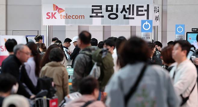 Travelers line up at Incheon International Airport on May 2 to replace their SIM cards at the SK Telecom Roaming Center before departure. [NEWS1]