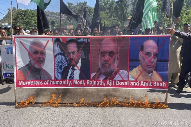 [무자파라바드=AP/뉴시스] 25일(현지 시간) 파키스탄령 카슈미르 무자파라바드에서 인도 정부의 수자원 공유 중단을 규탄하는 시위에 나선 카슈미르 난민 단체 회원들이 나렌드라 모디 인도 총리 등의 사진이 담긴 현수막을 불태우며 구호를 외치고 있다. 앞서 인도 정부는 카슈미르 총격 테러에 따른 조치로 국경 폐쇄, 물 공유 중단, 자국 내 파키스탄인에 대한 출국 조치 등 파키스탄에 대한 외교적 대응을 결정한 바 있다. 2025.04.25. /사진=민경찬