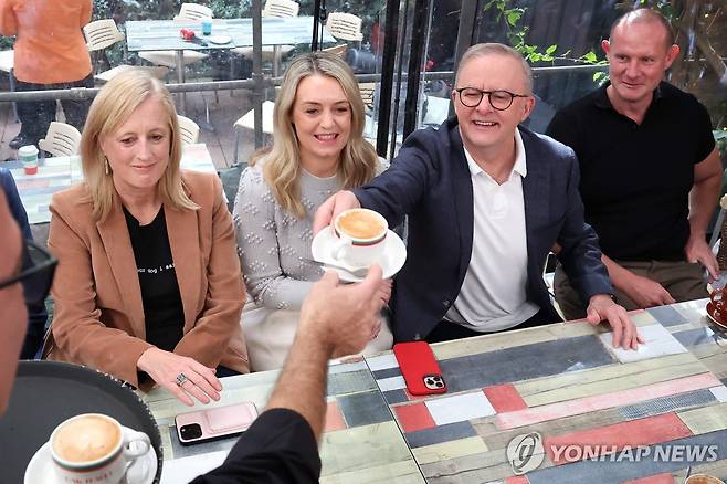 총선 압승 앨버니지 호주 총리 (시드니 AFP=연합뉴스) 총선 승리 다음 날인 4일(현지시간) 오전 호주 시드니의 단골 카페를 방문한 앤서니 앨버니지 호주 총리(오른쪽에서 2번째)가 커피를 받고 있다. 2025.05.04