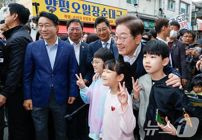 이재명 더불어민주당 대통령 후보가 2차 골목골목 경청투어에 나선 5일 오후 경기 양평군 양평시장의 문구점 앞에서 어린이들과 기념 촬영하고 있다. 2025.5.5/뉴스1 ⓒ News1 안은나 기자