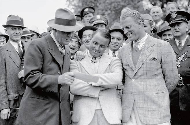 1935년 4월 8일 촬영된 이 사진에서 진 사라센(중앙)은 조지아주 오거스타 내셔널 골프클럽에서 열린 오거스타 내셔널 인비테이셔널 토너먼트 우승 후 1500달러 수표를 받고 있다. /AP연합