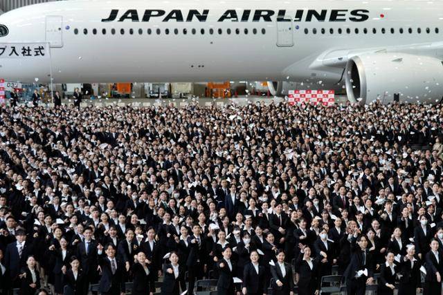 일본항공(JAL) 신입사원들이 지난해 4월 1일 도쿄 하네도공항 비행기 정비 격납고에서 열린 입사식에 참석해 종이비행기를 던지고 있다. 도쿄=EPA 연합뉴스