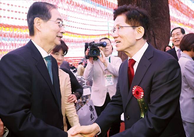 < 두 후보 악수 나눴지만… > 김문수 국민의힘 대선 후보(오른쪽)와 한덕수 무소속 예비후보가 5일 불기 2569년 부처님오신날을 맞아 서울 조계사에서 열린 봉축법요식에 참석해 악수하고 있다.  /김범준 기자