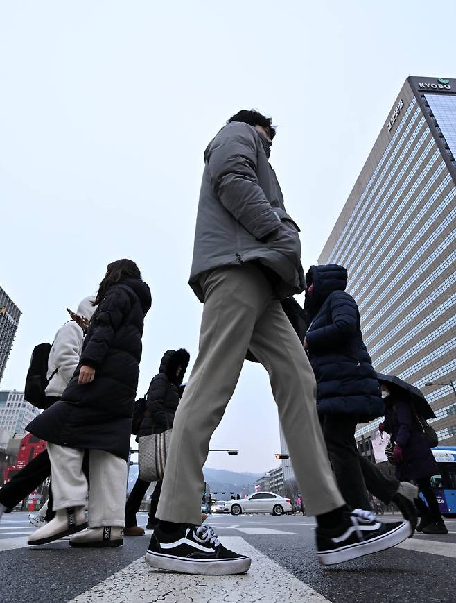 Pedestrians cross a street in Seoul’s Gwanghwamun business district on Jan. 31, the first working day following the Seollal holiday. (Im Se-jun/The Korea Herald)