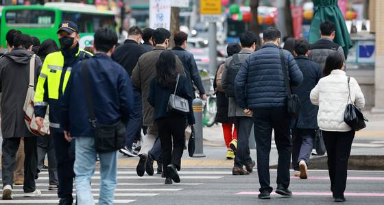 Office workers head to work across Gwanghwamun Square in Jongno District, central Seoul, on April 14. [NEWS1]