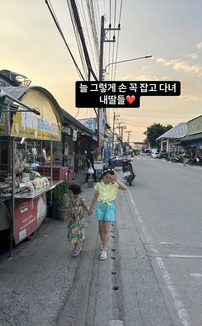 치앙마이 골목길을 손 꼭 잡고 걷는 자매의 모습이 담겼다. 사진=이지혜 SNS