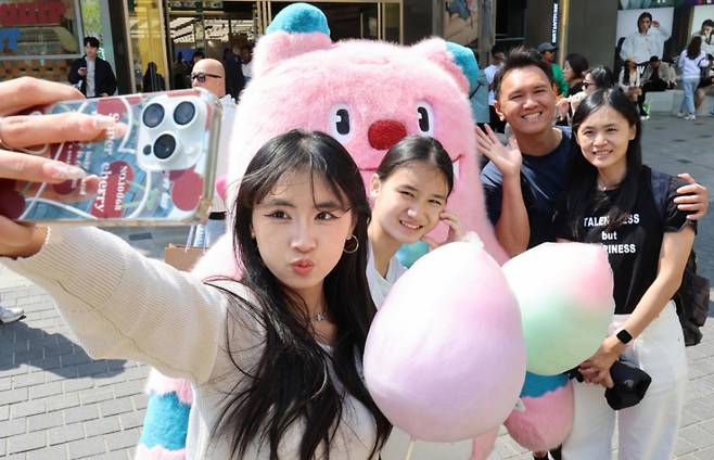 25일 오후 서울 중구 명동 밀리오레 앞에 마련된 '2025 서울환대주간, 서울여행정류소'에서 외국인 관광객들이 서울시 캐릭터인 해치와 추억을 남기고 있다. / 사진 = 뉴시스