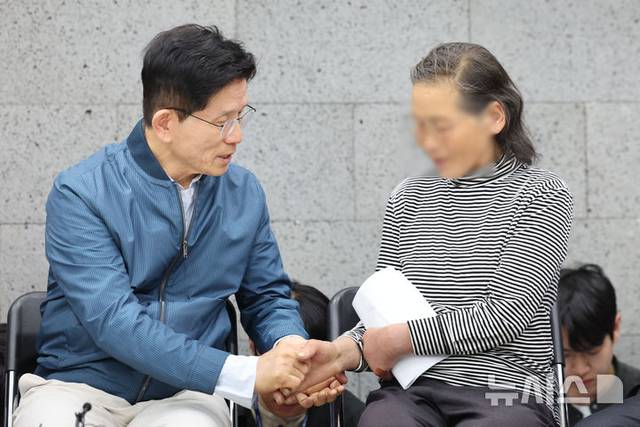 김문수 국민의힘 대선 후보가 4일 경기 포천시 한센인마을을 방문해 간담회를 갖고 주민 편지 낭독을 들은 뒤 주민 손을 잡아주고 있다.  뉴시스 제공