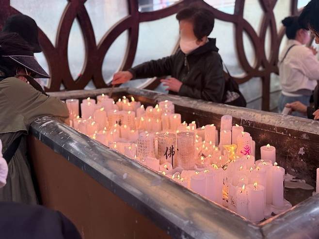 [서울=뉴시스] 이수정 기자=5일 오전 서울 조계사를 찾은 시민들이 향초에 불을 붙이고 염원을 담아 기도하고 있다. 2025.05.05. crystal@newsis.com  *재판매 및 DB 금지