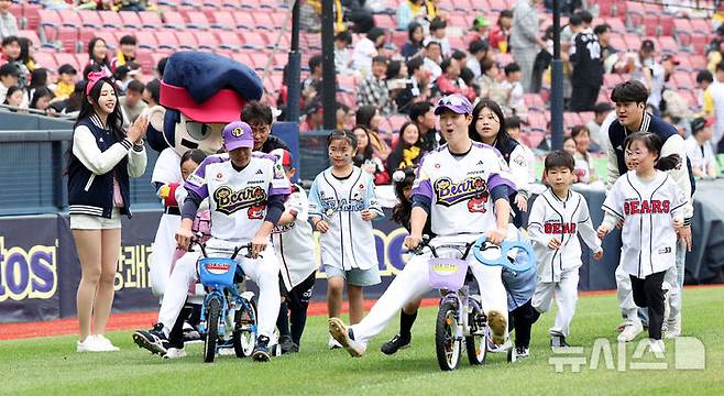 [서울=뉴시스] 김선웅 기자 = 어린이날인 5일 서울 송파구 잠실야구장에서 열린 2025 프로야구 LG 트윈스 vs 두산 베어스의 경기 시작 전 두산 박지훈, 김민석이 어린이용 자전거를 타고 어린이날 기념 미니 운동회에 참여하고 있다. 2025.05.05. mangusta@newsis.com